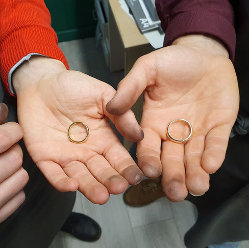 Two hands holding hanmade wedding rings
