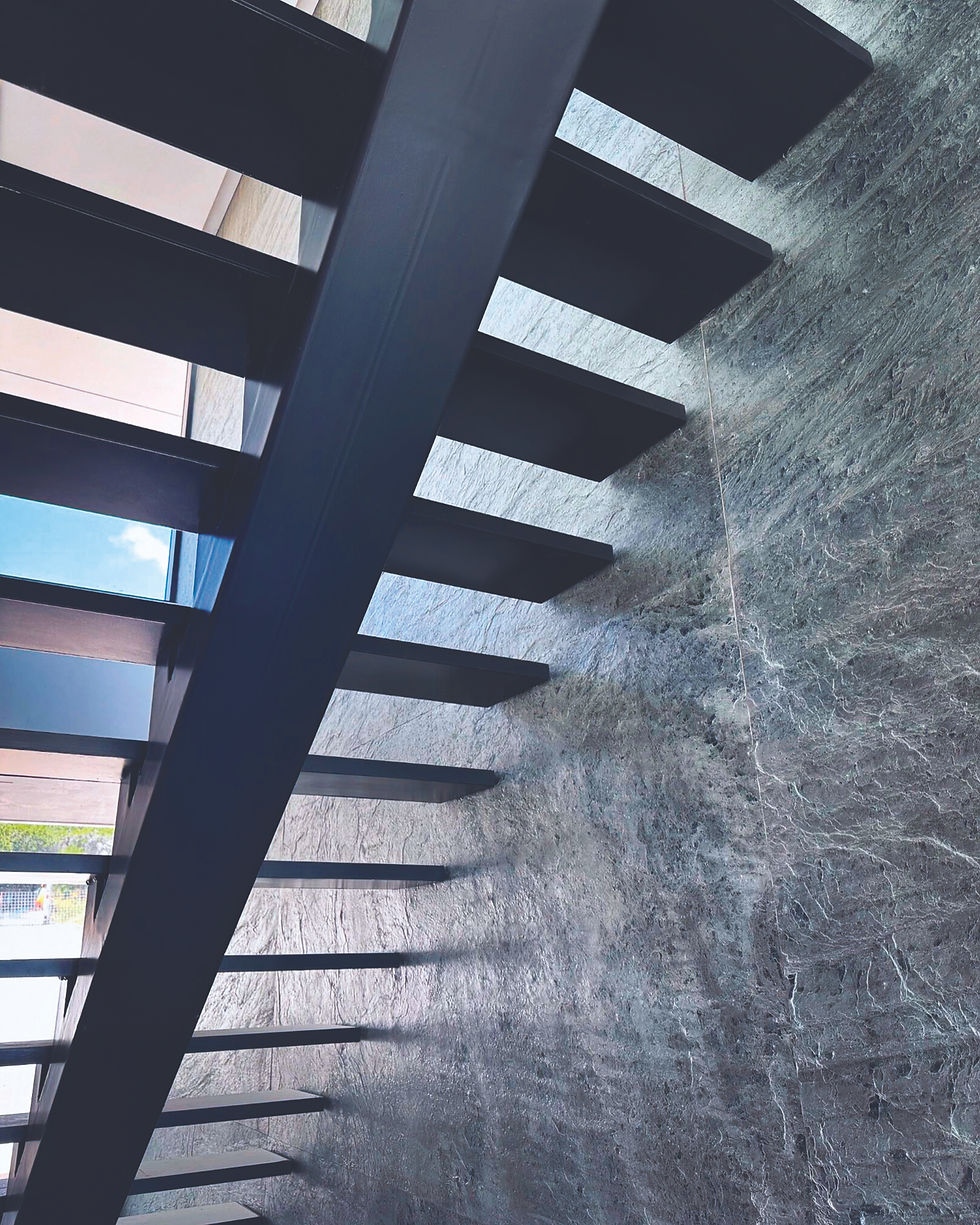Modern ornamental metals staircase against a textured wall