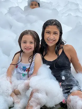 2 girls playing at foam party 