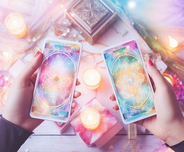 A person holding two tarot cards, showcasing intricate designs and vibrant colors against a neutral background.