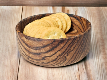A wooden bowl filled with freshly baked biscuits, showcasing their golden-brown color and flaky texture.