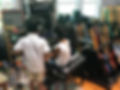 Three children are wearing headphonew with their backs to the camera. They are in a recording studio and singing in the microphone together.
