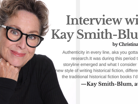 Smiling woman with glasses, wearing black, rests chin on hand. Text reads: "Interview with Kay Smith-Blum by Christina Boyd."