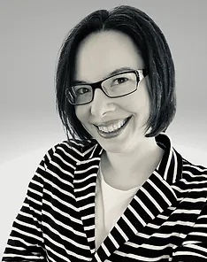 Smiling White woman with cropped dark hair and glasses 