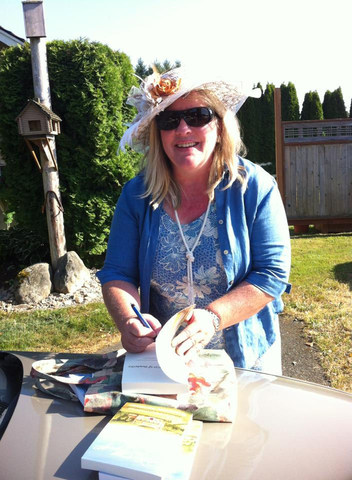 Blonde woman wearing hat, strand of pearls and blue cardigan, signing books