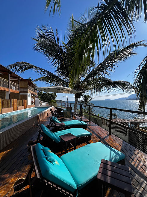 Piscina, espreguiçadeiras e vista para o mar no Solariun Beach Hotel, em Ilhabela.