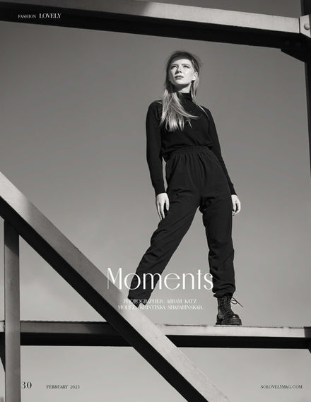 Black and white portrait of woman standing on structure by Abram Katz, published in Lovely Magazine.