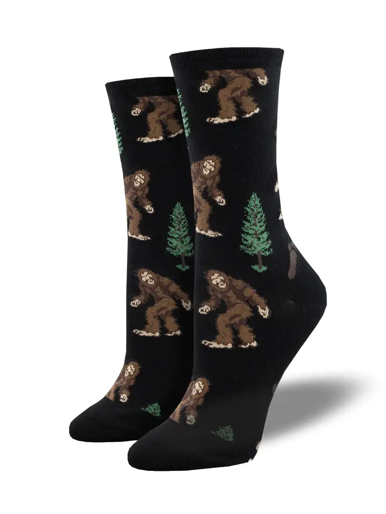 Pair of black socks with print of brown gorilla-like bigfoots & green trees