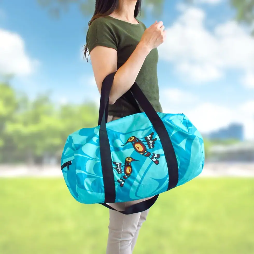 Model holding long round 2 handled zippered travel bag printed with artist Francis Dick's painting, 'Hummingbird'