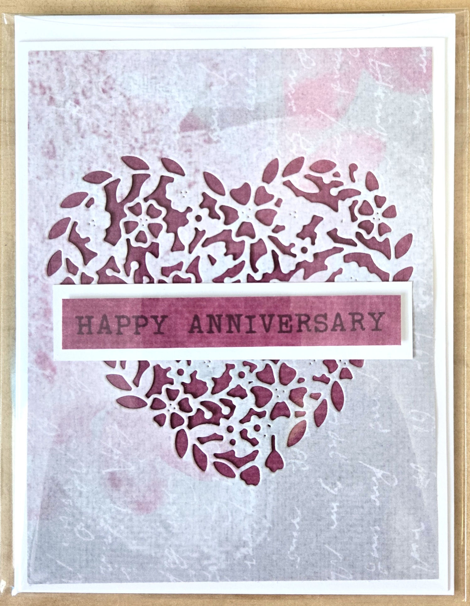 Gary print card with intricate floral heart cutout with burgundy background, message, 'Happy Anniversary'