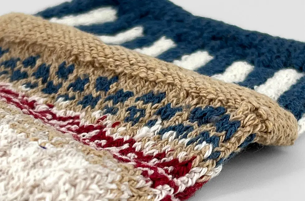 Close up of navy tan & red mismatched striped patterned socks