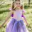 Thumbnail: Little girl wearing purple & lilac fancy fairy tunic with sequined bodice, full skirt & tie ribbons on sides