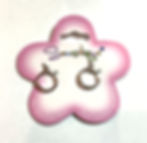 Pink & white flower shaped card holding pair of silver coloured metal hoop earrings with click back