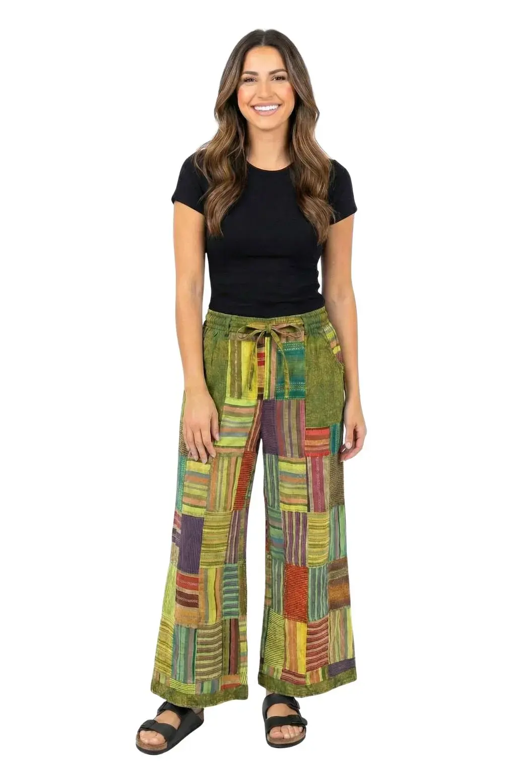 Front view of model in wide leg mainly green striped patchwork pants with drawstring waist
