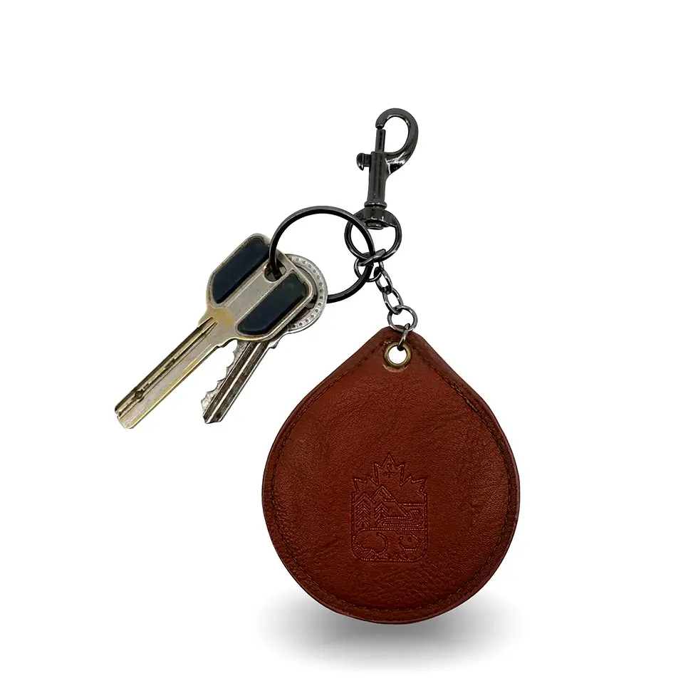 The reverse side of a leather keychain featuring a debossed emblem of a beaver, mountains, & evergreen trees at Tickled Pink.