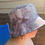 Thumbnail: Side view of girl wearing gray tie-dye bucket hat