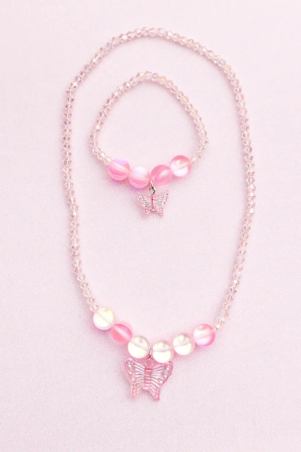 Pink crystal bead necklace with larger holographic beads on either side of pink butterfly pendant & matching bracelet