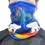 Thumbnail: Model wearing microfleece neck warmer pulled up over nose with print of artist Dawn Oman's painting 'Sky Watchers'