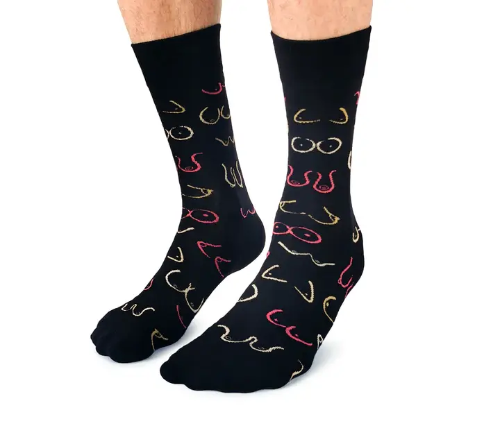 Angled front-left view of pair of black socks with print of wavy lines representing pairs of breasts in pink, yellow & white