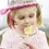 Thumbnail: Close up of little girl wearing pink ribbon tiara & eating a pinwheel striped lollipop