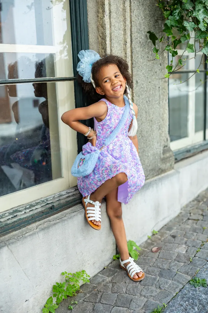 Little girl wearing fuzzy periwinkle crossbody purse with embroidered heart