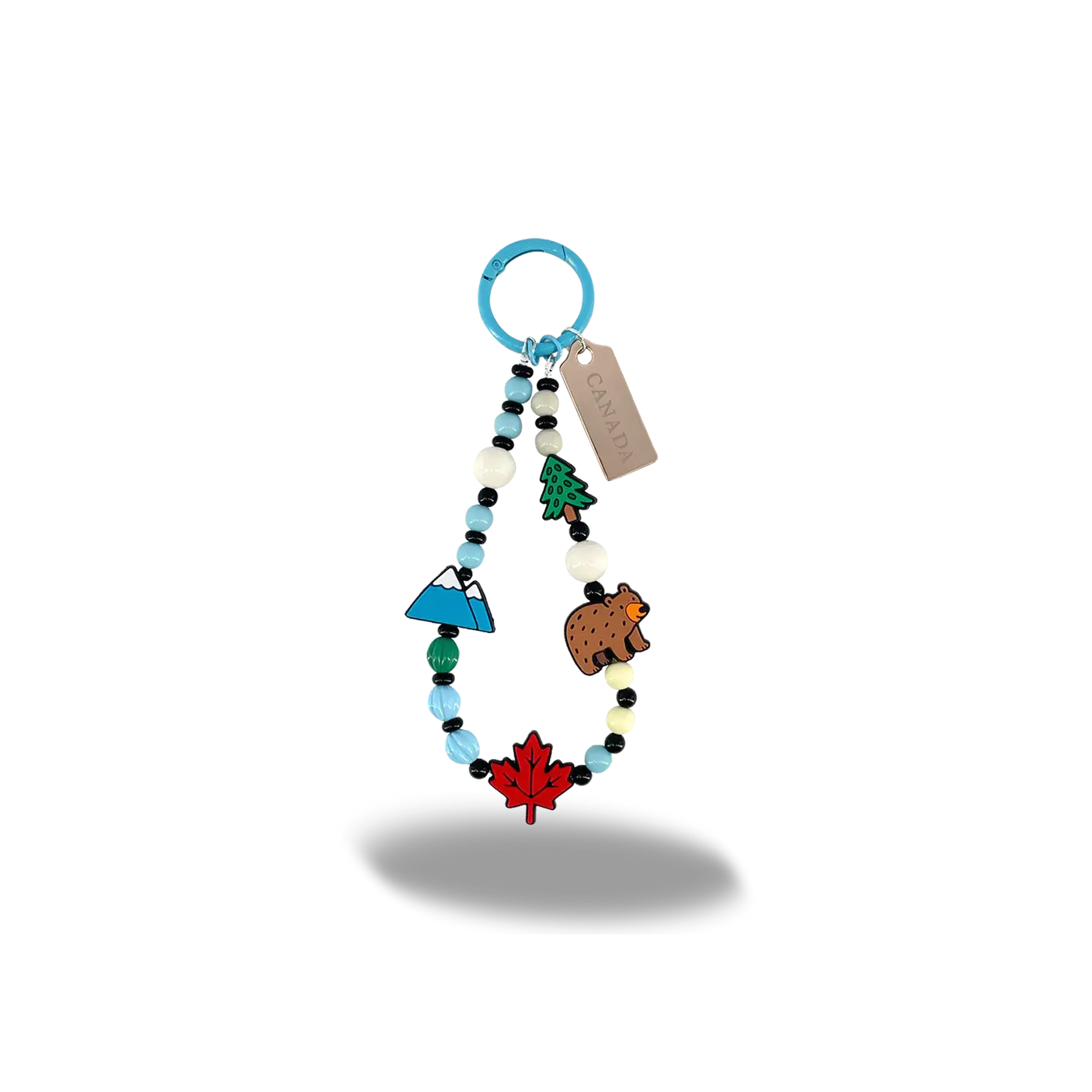 Beaded Canada bag charm with miniature mountain, bear, pine tree, and maple leaf charms at Tickled Pink.