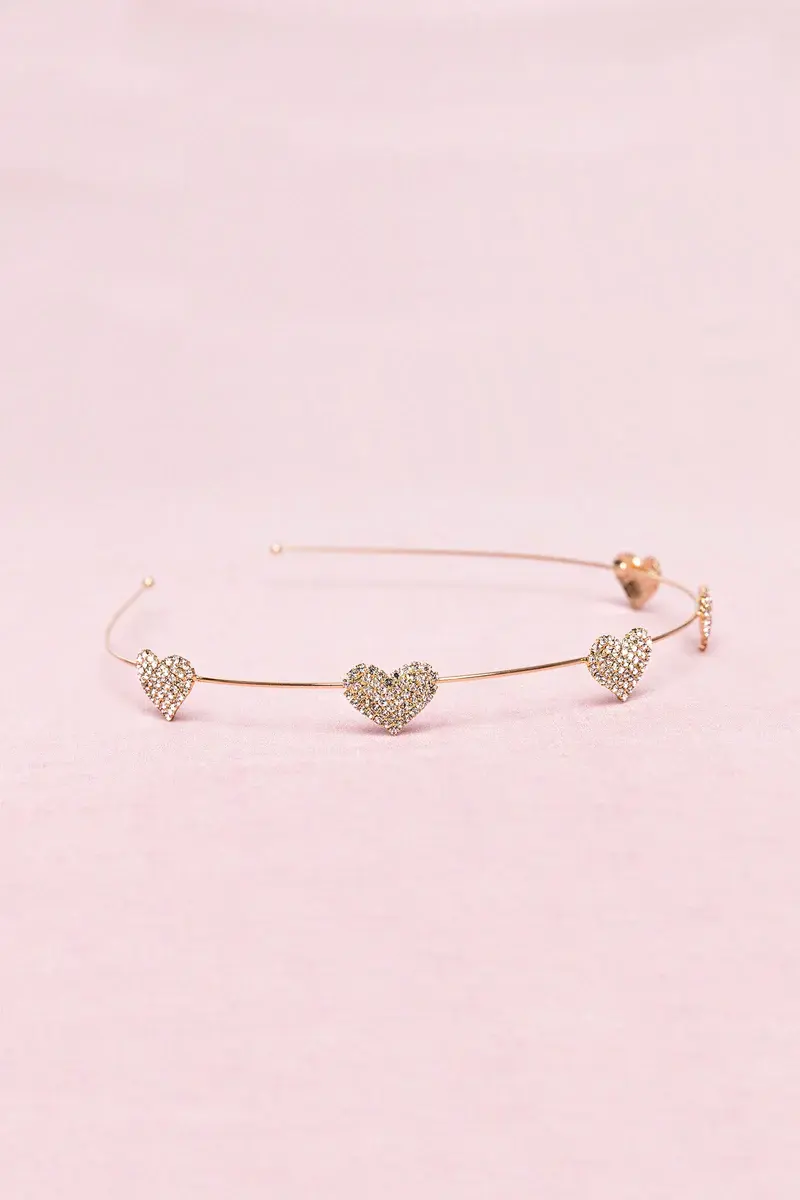 Thin metal headband with 5 rhinestone hearts spaced along the band