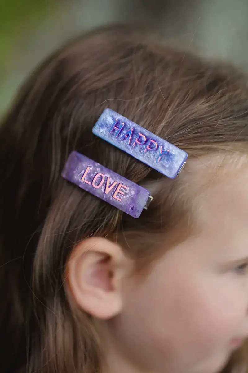 Close up of little girls hair with HAPPY & LOVE hairclips