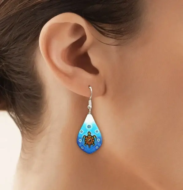 Thumbnail: Model wearing the Medicine Turtle teardrop earring by James Jacko at Quichua World Market in downtown Ottawa.