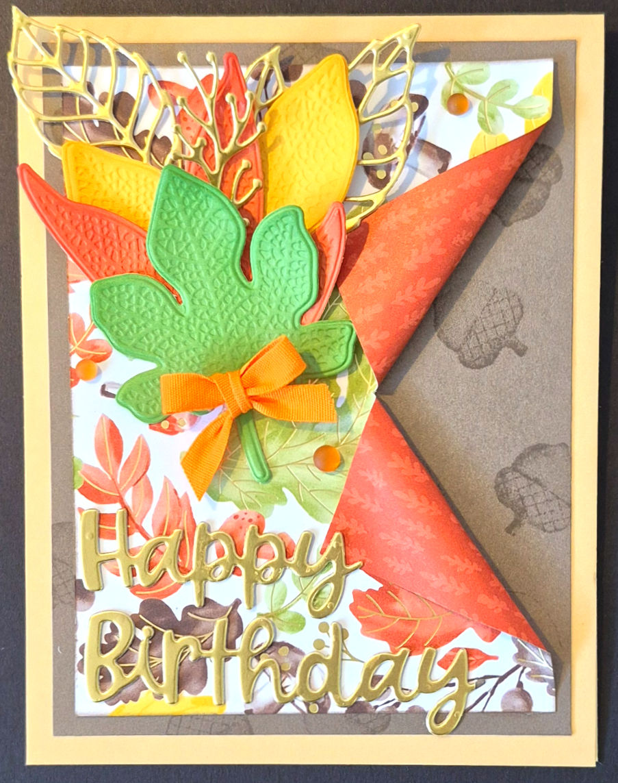 A handmade birthday card with a folded corner design, textured maple leaves, and a ribbon bow at Tickled Pink.