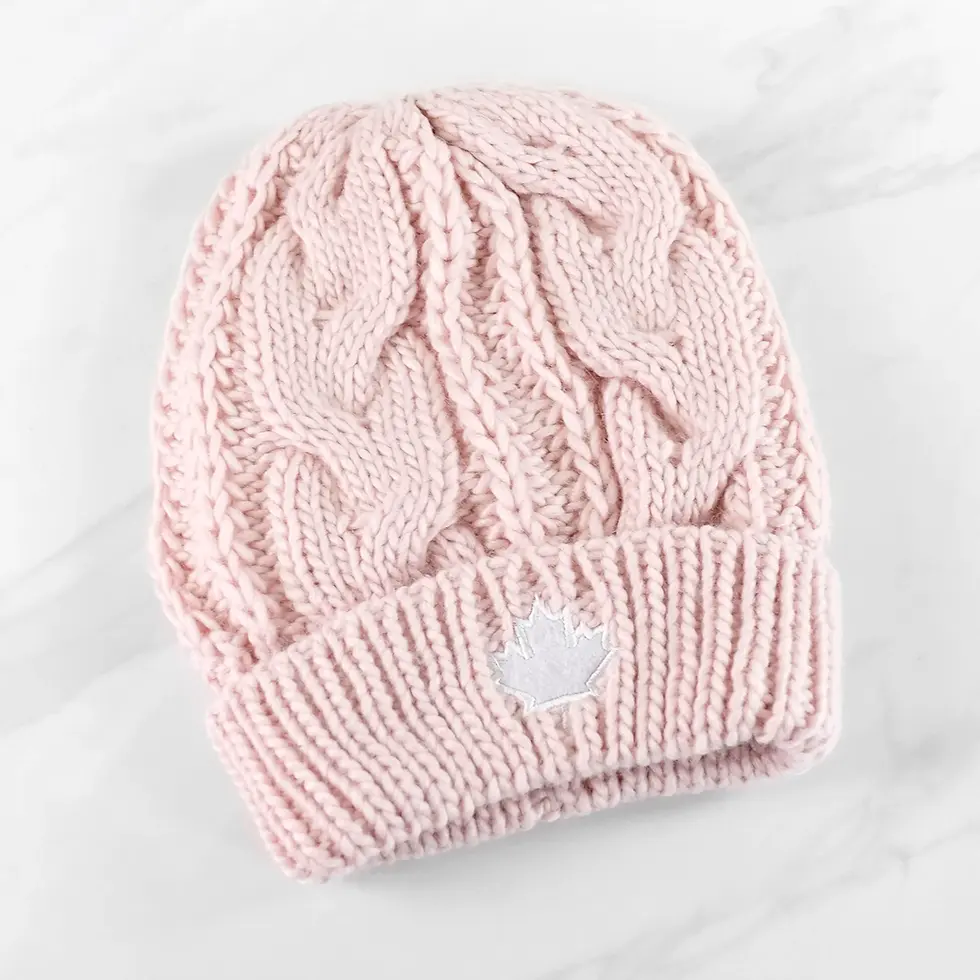 Pink cable-knit beanie with small white maple leaf applique at front