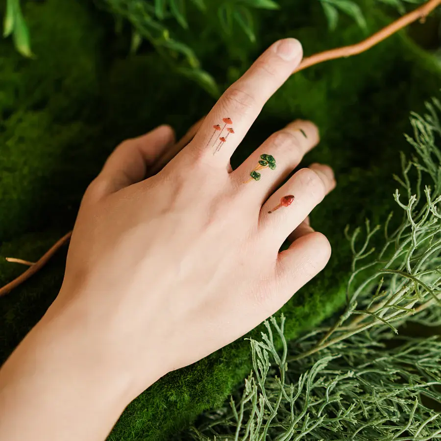 Thumbnail: Hand with mushroom tattoos on fingers