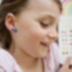 Close up of girl's ear wearing 2 stick-on earrings
