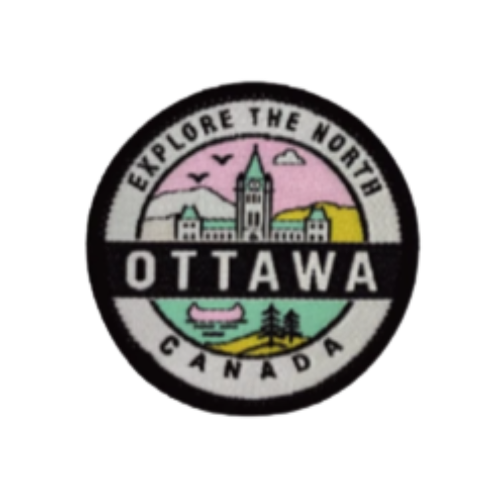 Circular embroidered Ottawa patch with a black merrowed edge featuring a pink sky, the Peace Tower, and a canoe at Tickled Pi