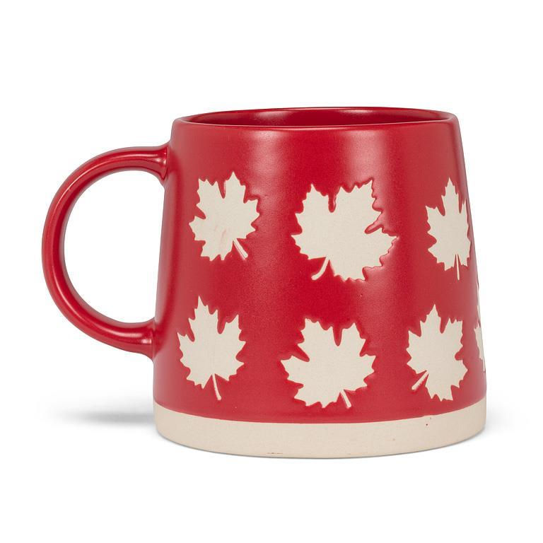 Back view of bright red mug with wider base than top, print of maple leaves all around