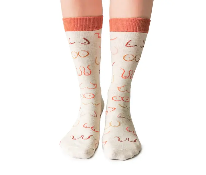 Front view of pair of cream socks with wavy lines representing breasts in orange, brown & rust