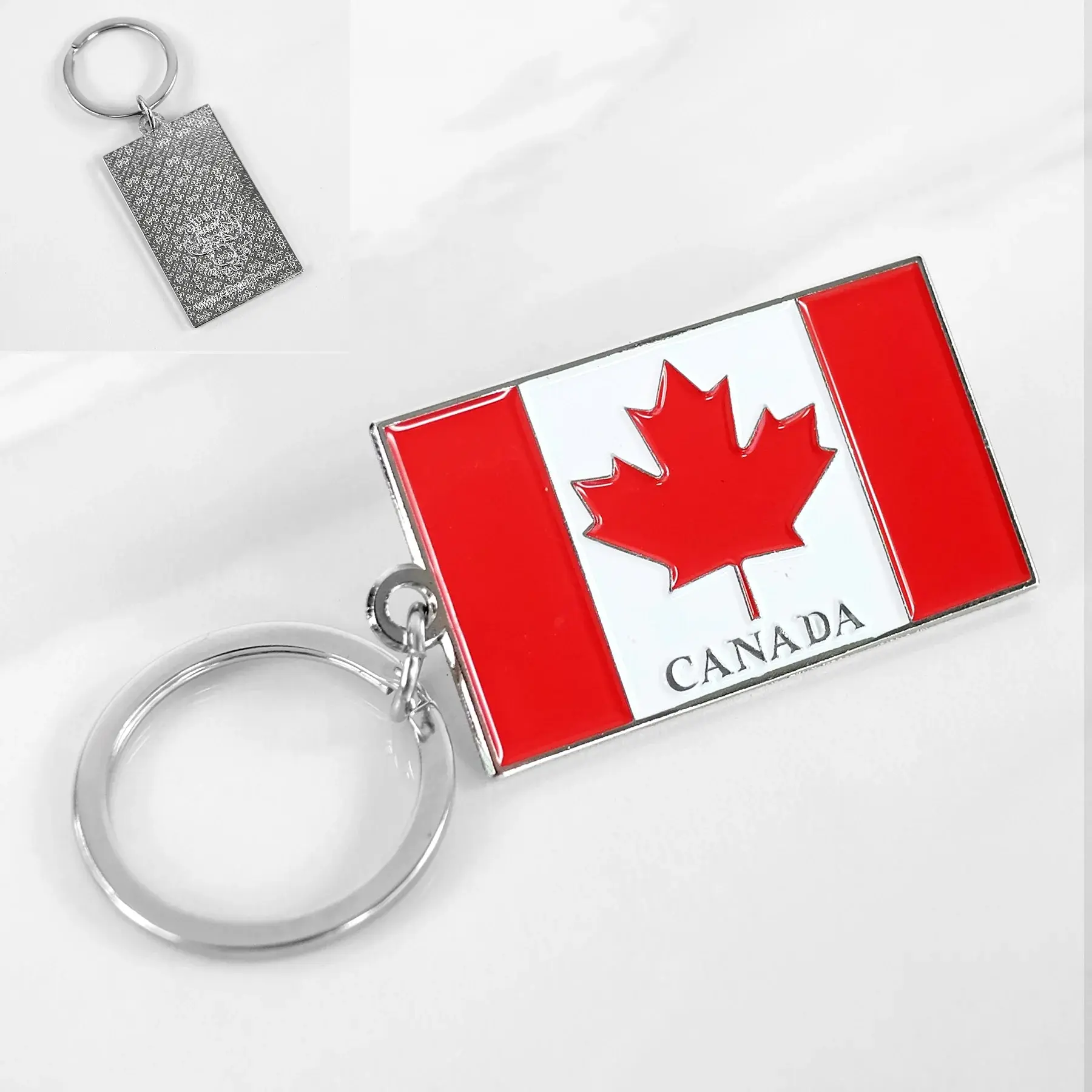 Canada Flag metal keychain showing the front flag design and textured back at Tickled Pink.