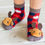 Thumbnail: Child's feet wearing black & red checkered socks with fuzzy brown moose on toes of sock