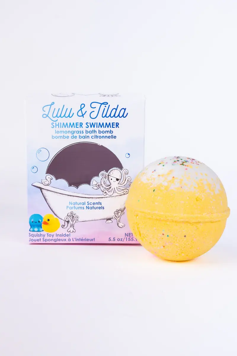 Bright yellow bath bomb beside Lulu & Tilda Swimmer Shimmer labeled box