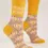 Thumbnail: Side view of pair of yellow socks with tan & beige print, text, 'Mind Reader'
