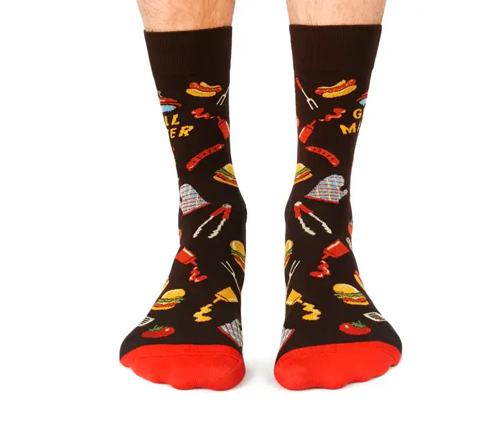 Front view of feet wearing black & red socks with BBQ print, text on side, 'Grill Master'