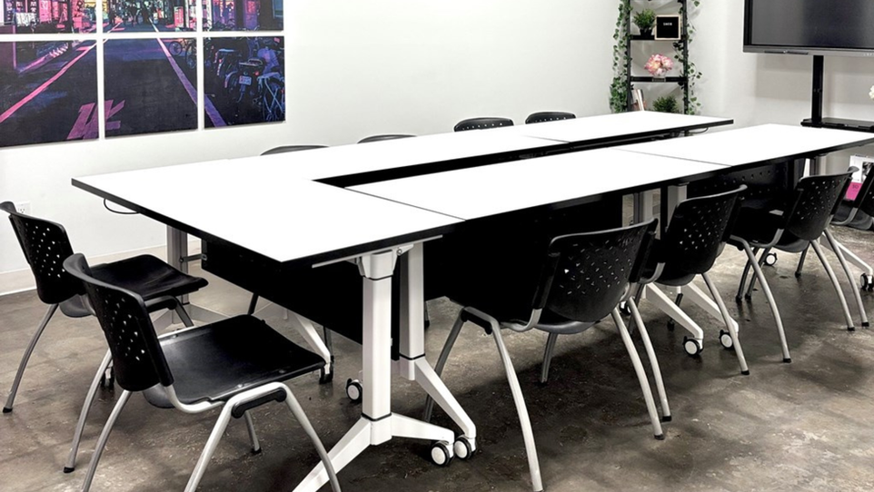 Boardroom meeting space with conference table, chairs, and TV for client presentations in Edmonton