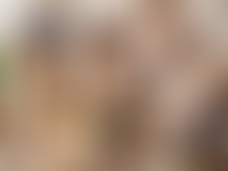 Four people in a bright kitchen: one packs a box, another organizes dishes, and two unload a dishwasher. Relaxed, cooperative mood.