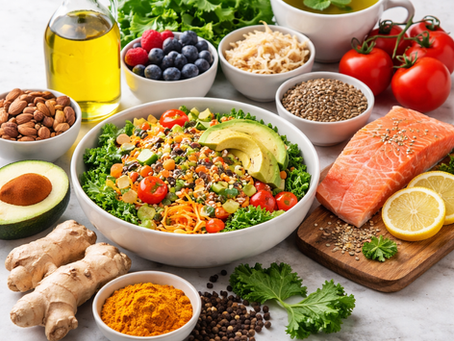 A vibrant salad with avocado and cherry tomatoes is surrounded by salmon, berries, nuts, herbs, and spices on a marble surface.