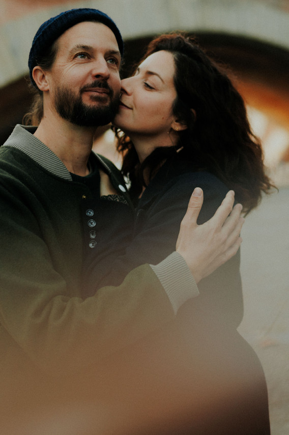 Couple enlacé devant les façades roses de Toulouse