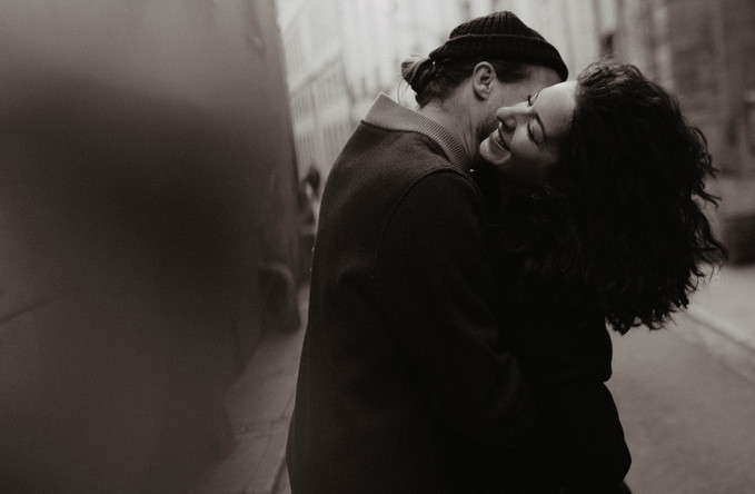 Couple riant ensemble pendant une séance photo urbaine