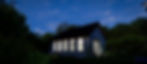 Small, white ADU by Sypher Design Build under a starry nighttime sky