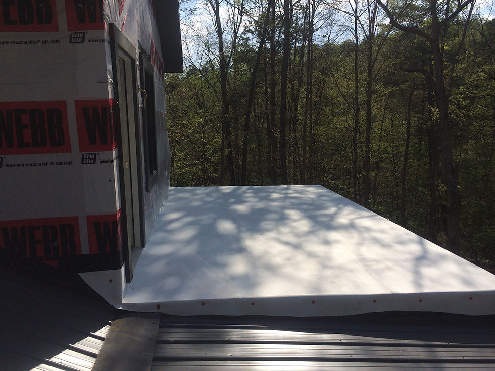 Flat roof on commercial building in the shade near some trees.