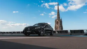 Une Mercedes-benz C63 AMG SE Performance sur un parking, avec une église en arrière plan