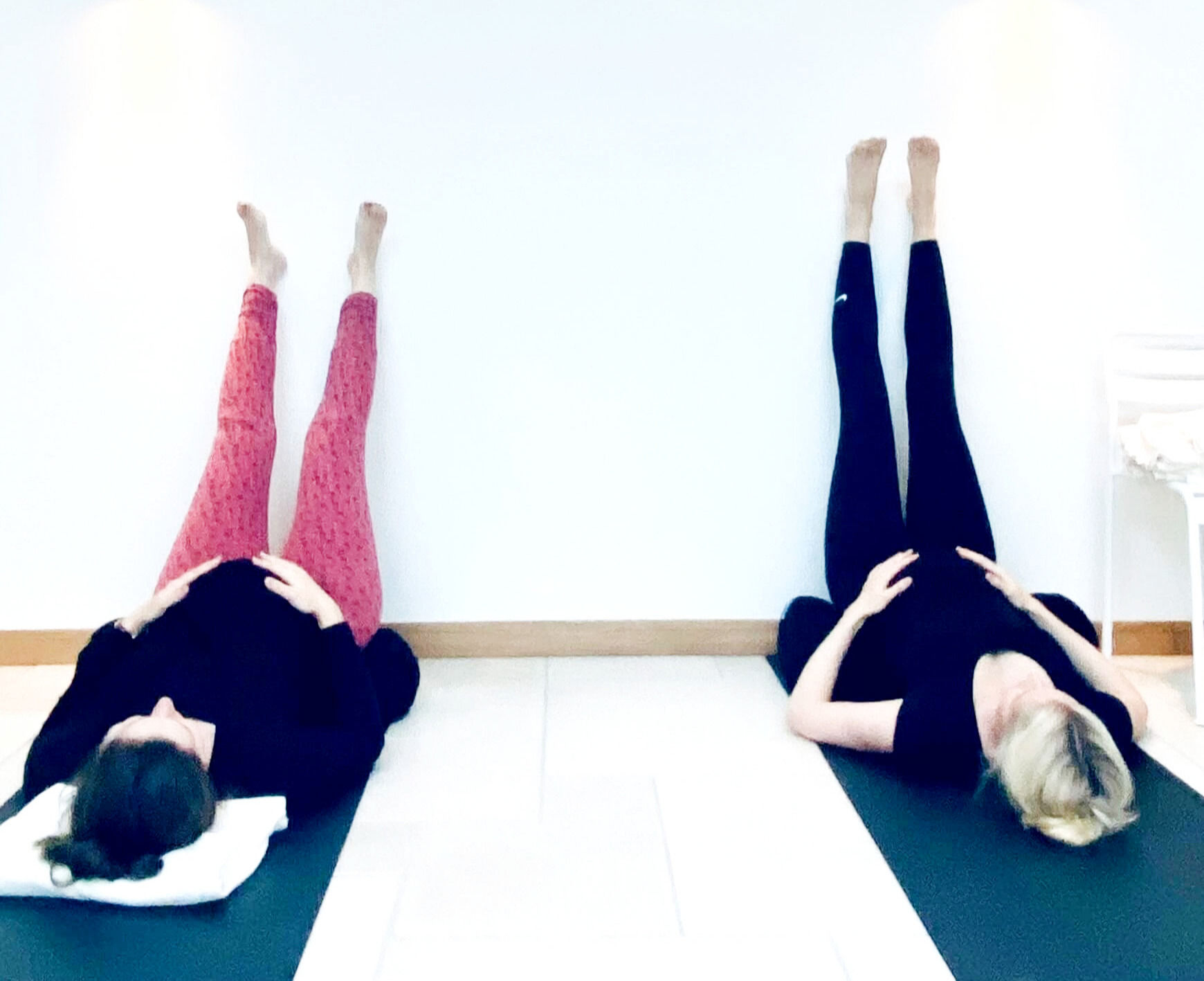 2 zwangere vrouwen in ontspannen houding tijdens zwangerschapsyoga les